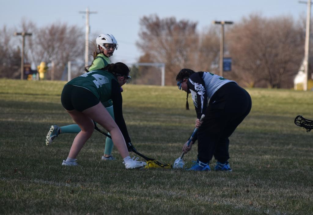 Rush girls lacrosse players facing off